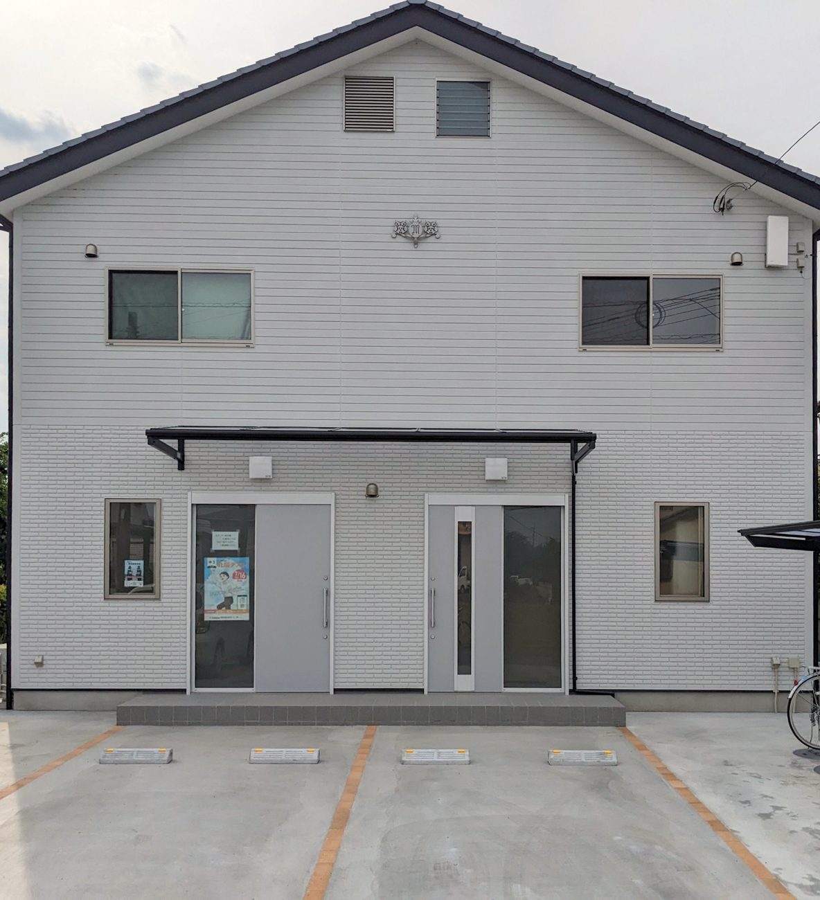 森田塾の外観。白い2階建ての建物で、前に駐車場があります